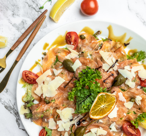 Carpaccio de salmón con parmesano, tomates cherry, alcaparras y alcaparrones.
