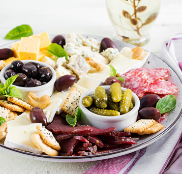Bandeja antipasto con basturma, salami, queso azul, nueces, encurtidos y aceitunas